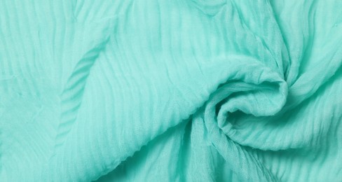 Texture of turquoise crumpled fabric as background, top view