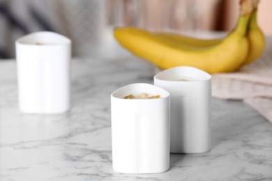 Photo of Cups of yogurt with bananas on table. Multi cooker recipe