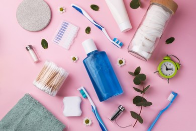 Photo of Flat lay composition with fresh mouthwash in bottle and personal care products on pink background. Daily routine