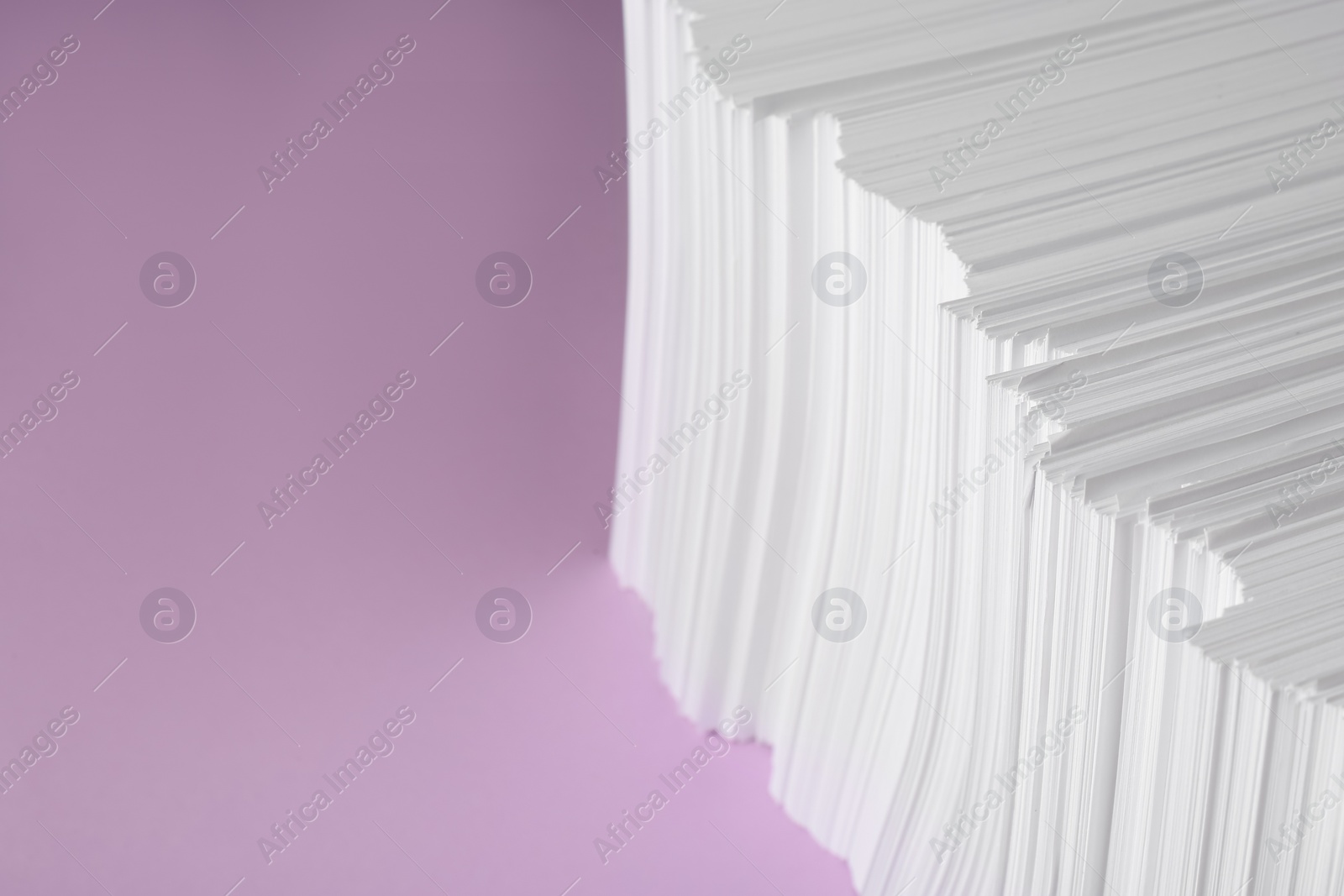 Photo of White paper sheets on violet background, space for text