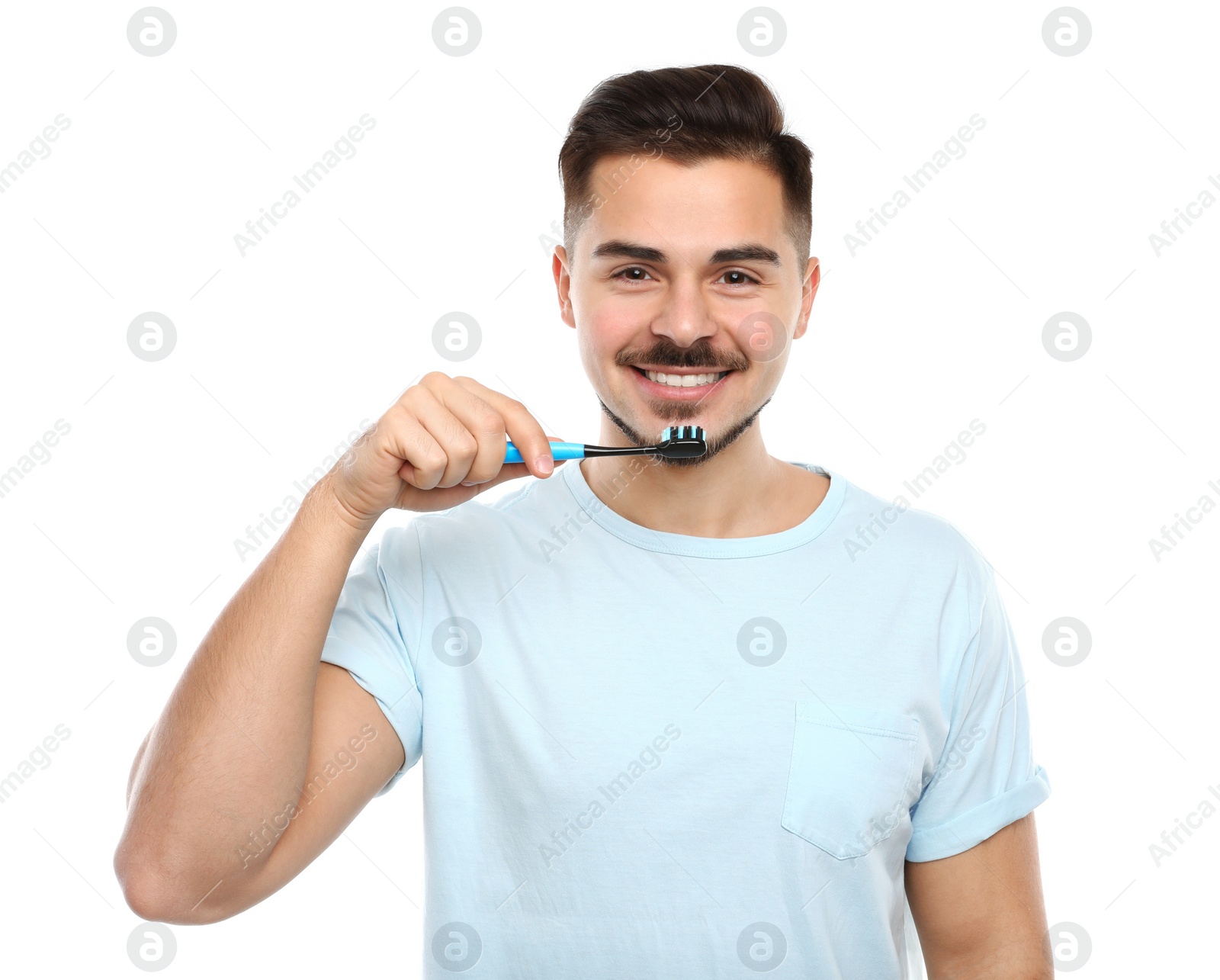 Photo of Young man brushing teeth on white background