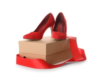 Photo of Pair of stylish high heel shoes and carton box on white background