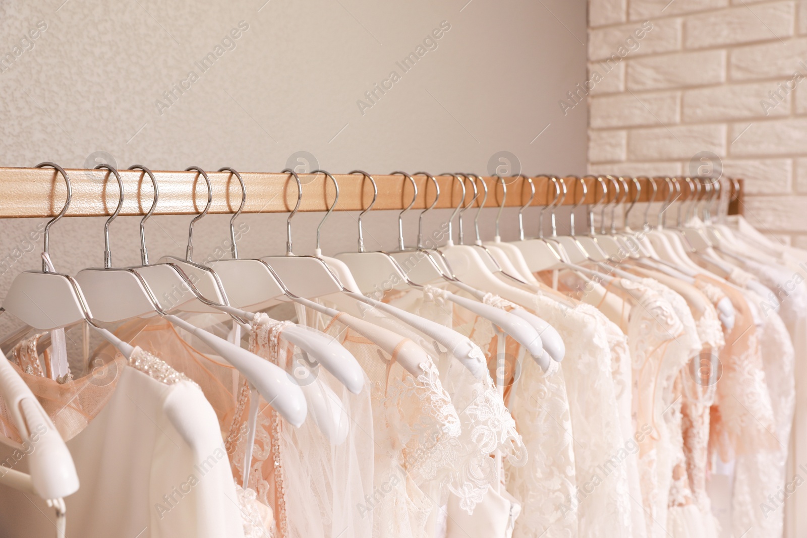 Photo of Different wedding dresses on hangers in boutique