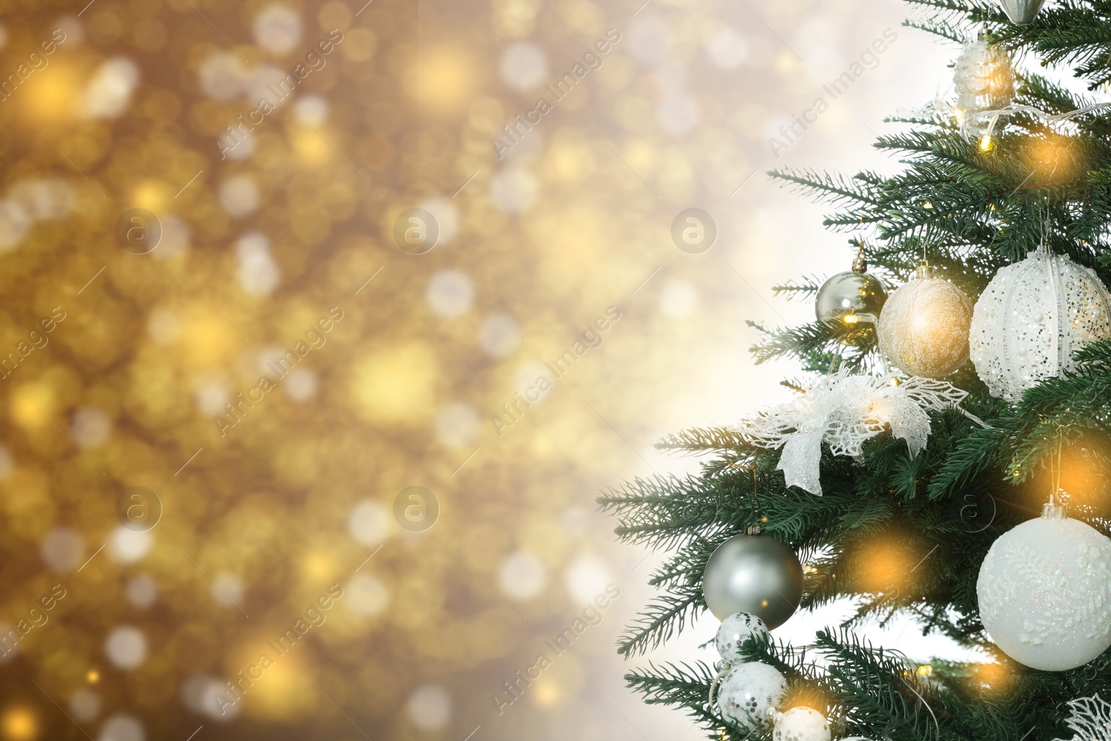 Image of Beautiful Christmas tree with bright baubles against blurred lights on golden background, closeup. Space for text