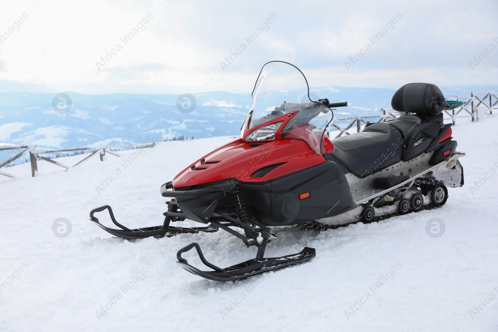 Photo of Modern snowmobile on hill at mountain ski resort