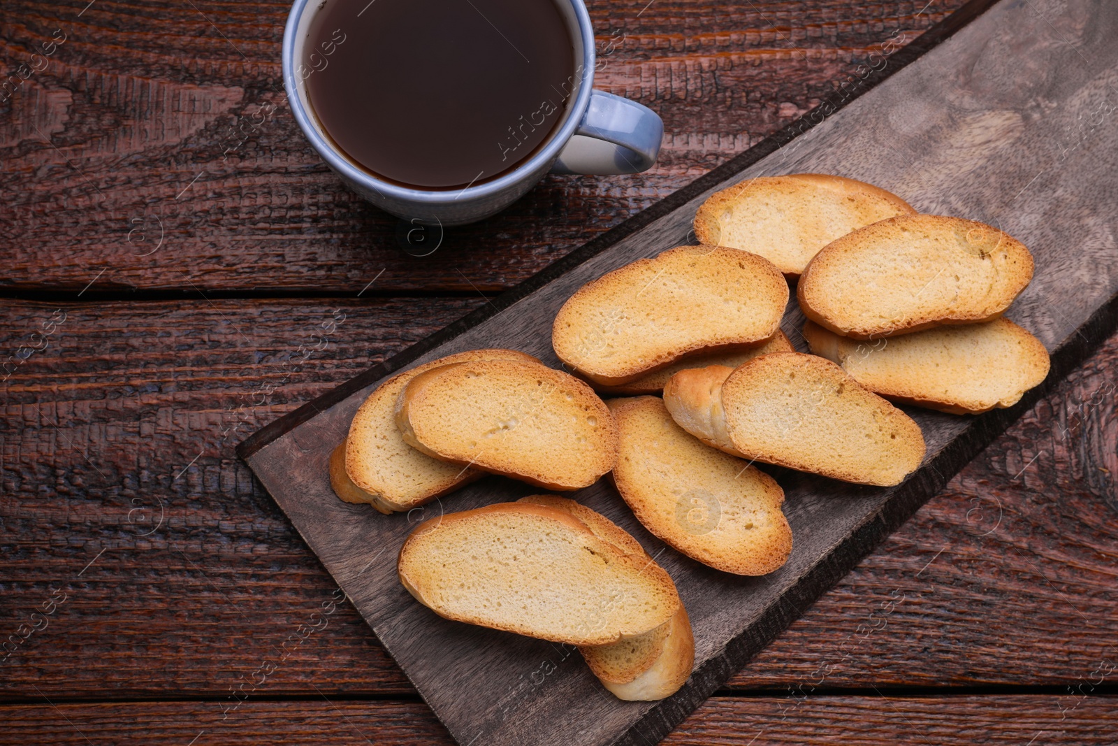 Photo of Hard chuck crackers and cup of tea on wooden table, flat lay