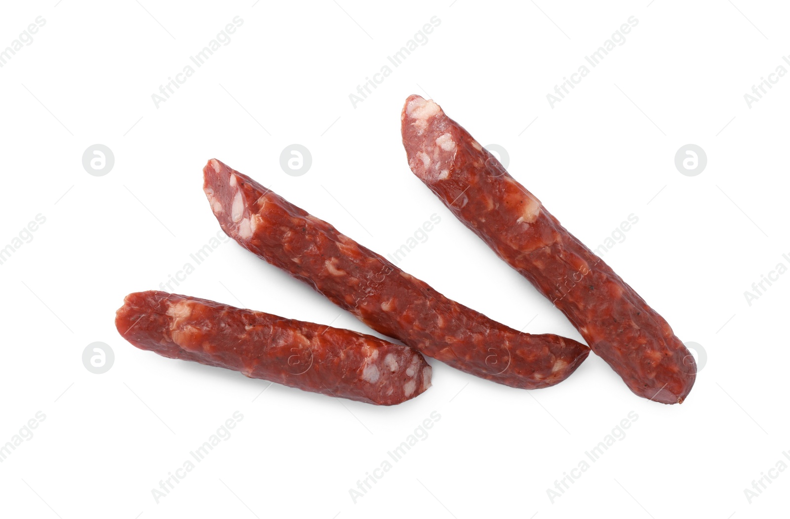 Photo of Thin dry smoked sausages isolated on white, top view