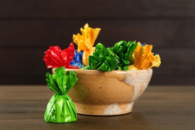 Candies in colorful wrappers on wooden table