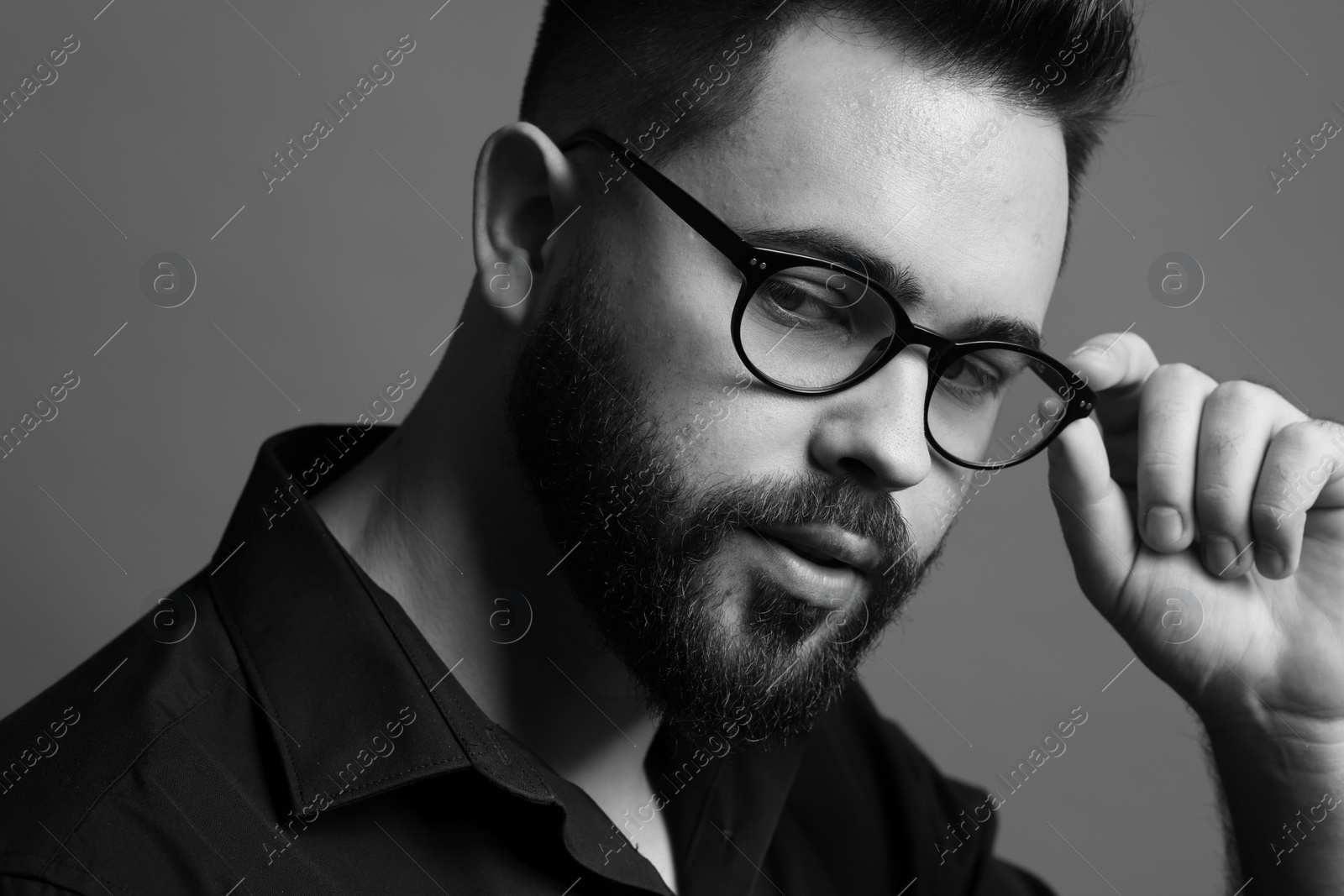 Photo of Portrait of handsome bearded man on grey background. Black and white effect
