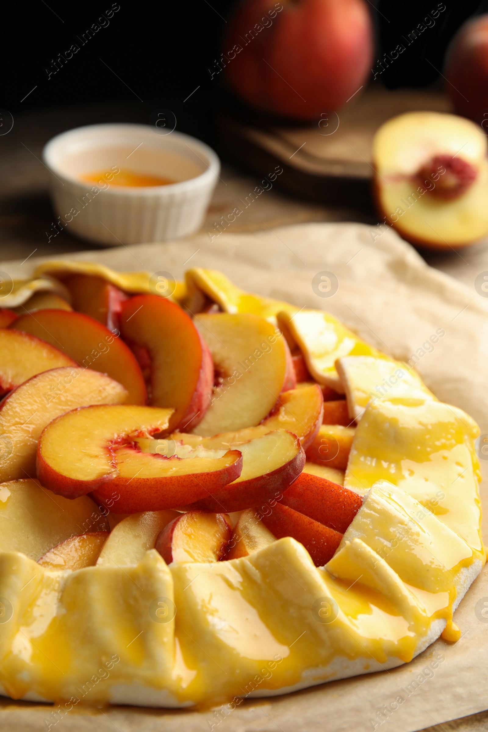 Photo of Uncooked peach pie on wooden table, closeup