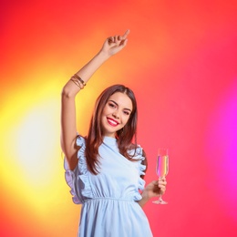 Photo of Portrait of happy woman with champagne in glass on color background