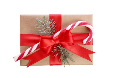 Image of Christmas gift box decorated with red bow, candy cane and fir tree branch on white background, top view