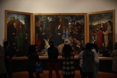Photo of Florence, Italy - February 8, 2024: Visitors admiring painting "Portinari Altarpiece" by Hugo van der Goes at Uffizi gallery