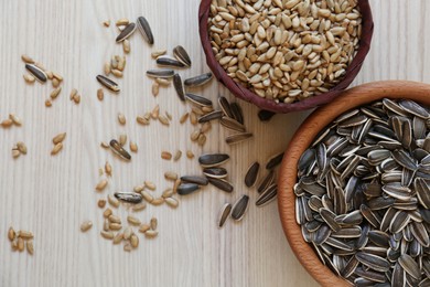 Photo of Organic sunflower seeds on white wooden table, flat lay