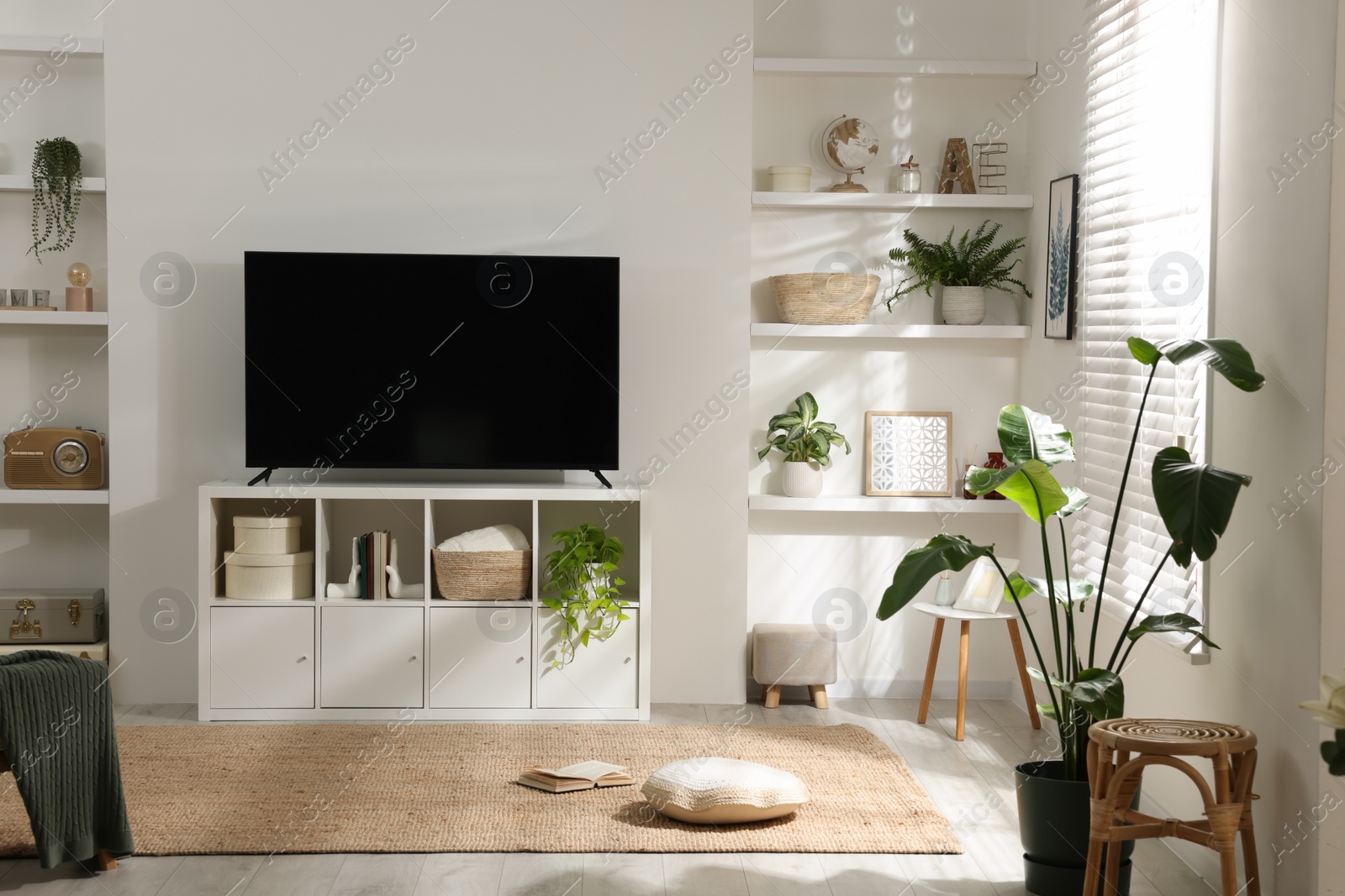 Photo of Stylish wide TV set on stand in room