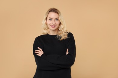 Photo of Happy woman in stylish warm sweater on beige background