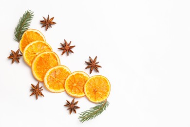 Photo of Dry orange slices, fir branches and anise stars on white background, flat lay. Space for text