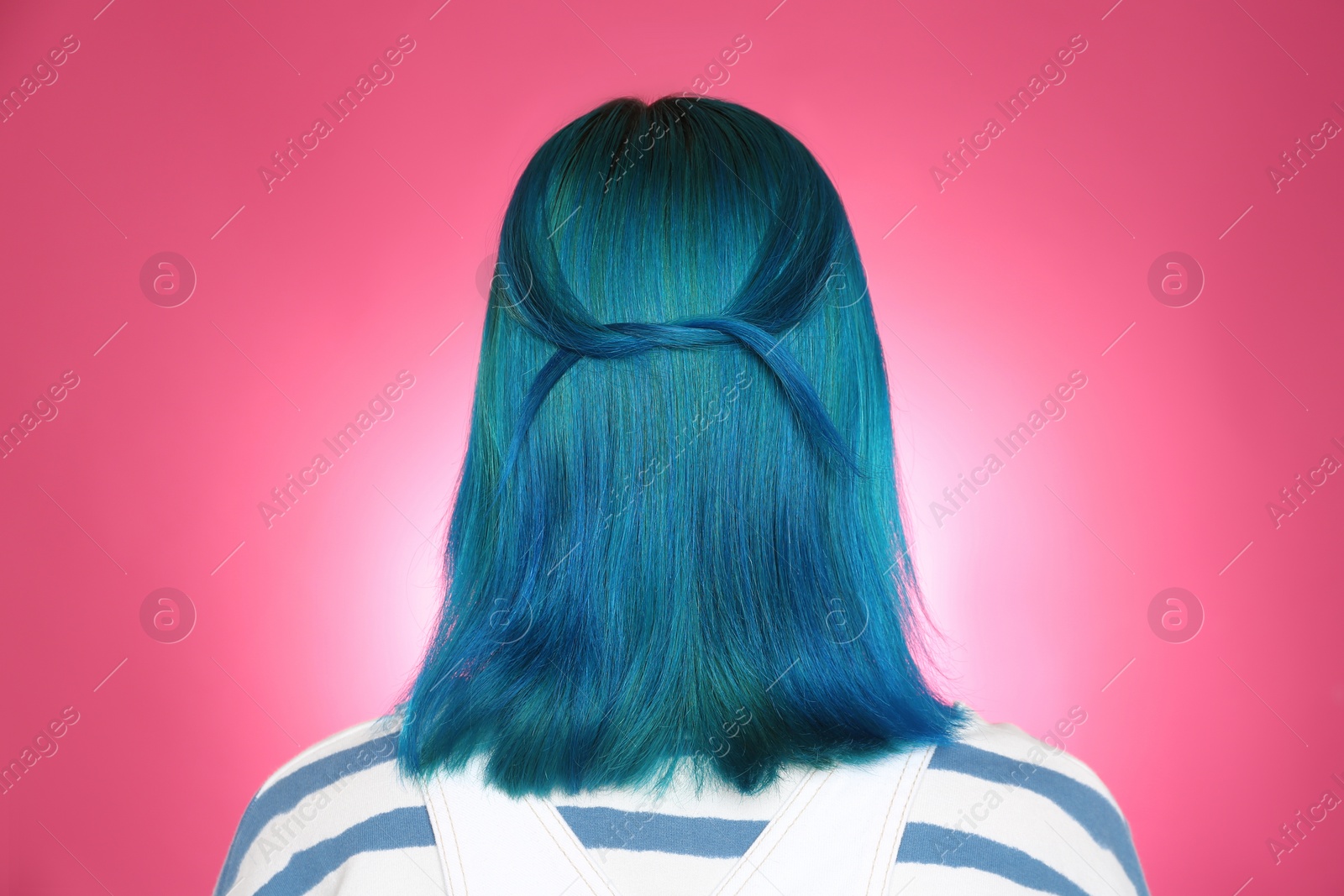 Photo of Woman with bright dyed hair on pink background, back view