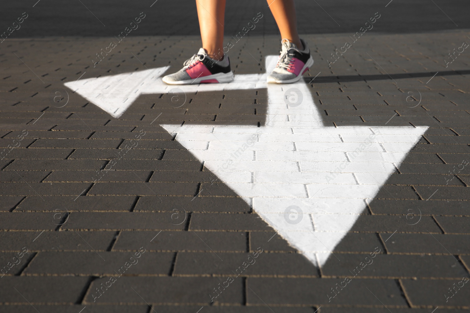 Photo of Woman going along road with arrows marking, closeup