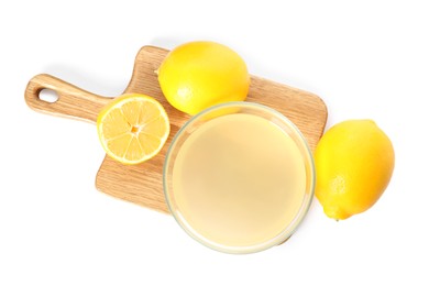 Freshly squeezed juice and lemons on white background, top view