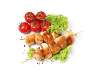 Delicious chicken shish kebabs and vegetables on white background, top view