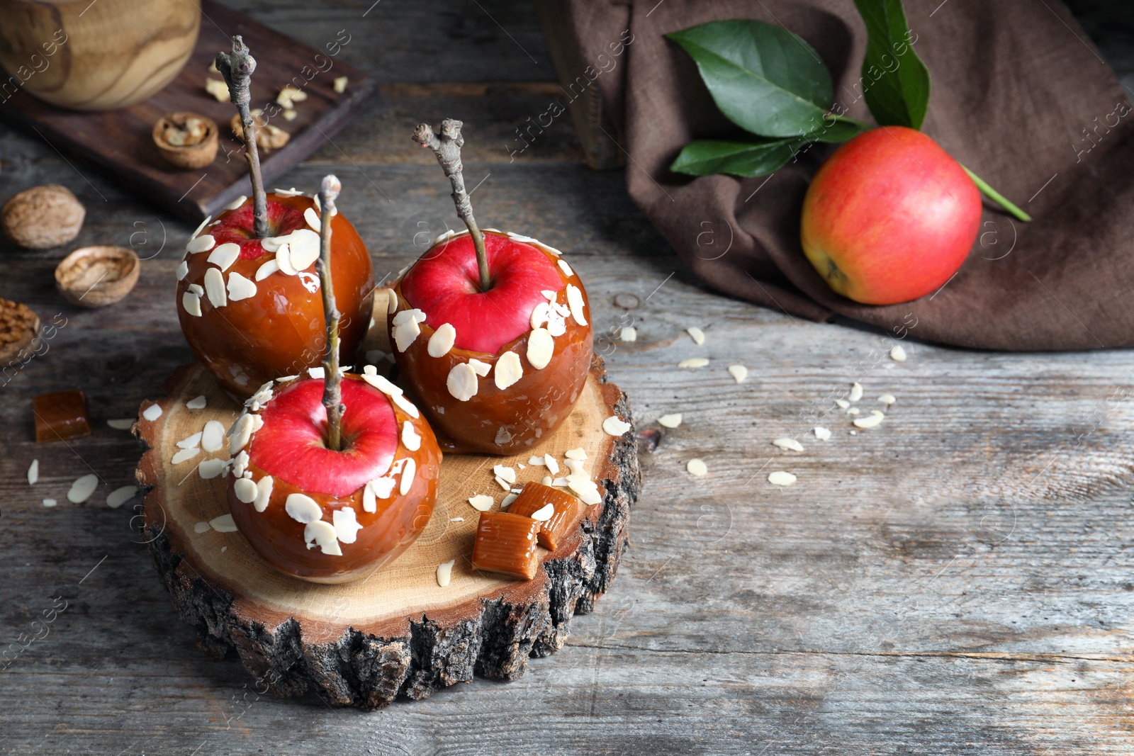 Photo of Delicious caramel apples on wooden serving board