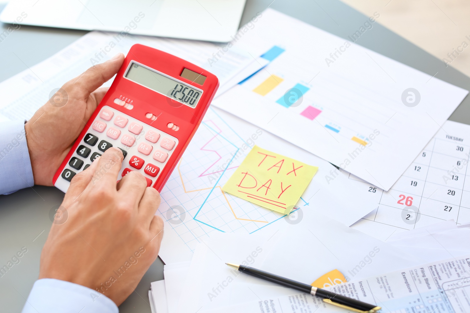 Photo of Tax accountant working with calculator at table