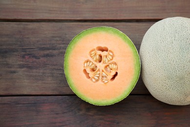 Photo of Whole and cut fresh ripe melons on wooden table, flat lay. Space for text