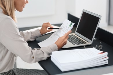 Photo of Businesswoman working with documents at grey table in office, closeup