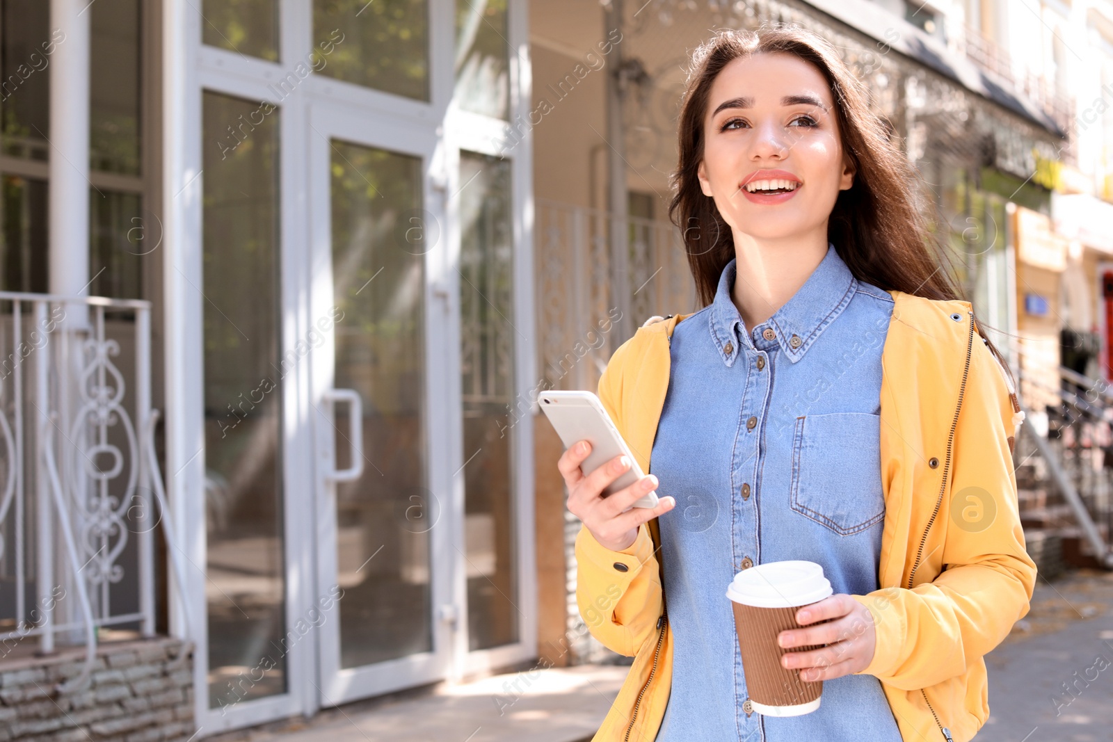 Photo of Young woman using phone outdoors on sunny day