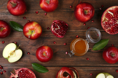 Photo of Honey, apples and pomegranate on wooden table, flat lay. Rosh Hashanah holiday