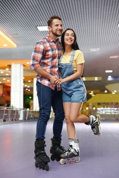 Photo of Young couple spending time at roller skating rink