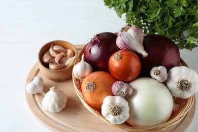 Fresh raw garlic, onions and parsley on white table, above view