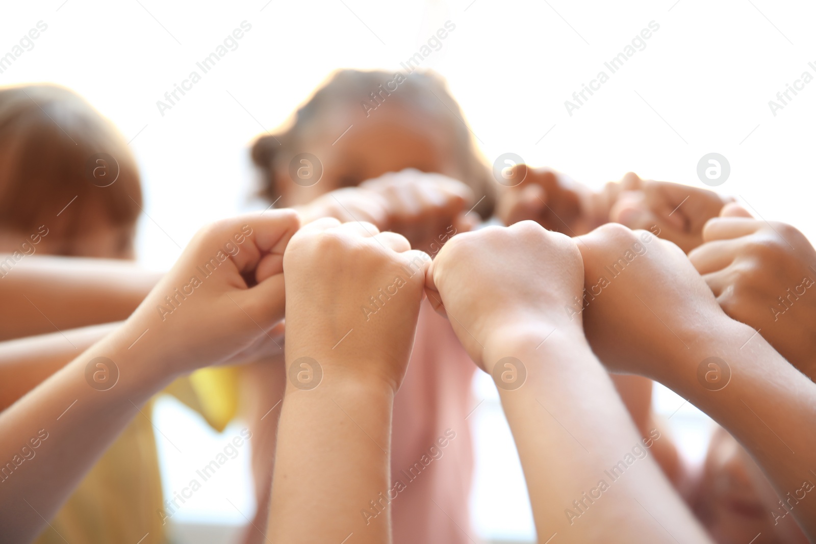 Photo of Little children putting their hands together, closeup. Unity concept