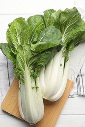 Photo of Fresh green pak choy cabbages on white wooden table, top view