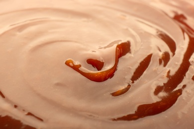 Photo of Delicious sweet caramel sauce as background, closeup