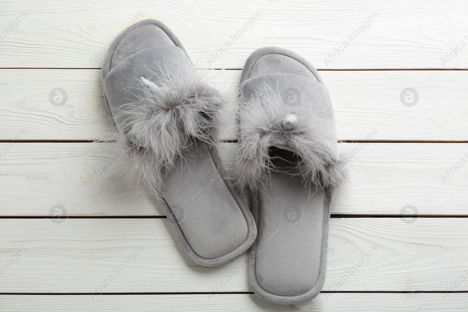 Photo of Pair of stylish soft slippers on white wooden background, flat lay