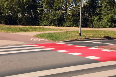 Bicycle lane with painted white sign and pedestrian crossing outdoors