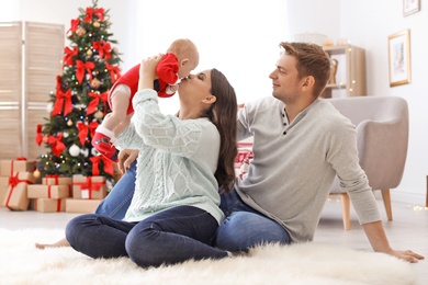 Photo of Happy couple with baby celebrating Christmas together at home