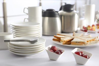 Table with different delicious snacks and dishware indoors. Coffee break