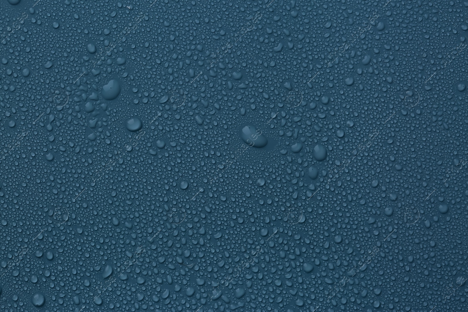 Photo of Many water drops on dark dusty blue background