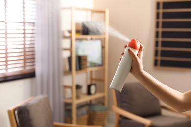 Photo of Woman spraying air freshener at home, closeup