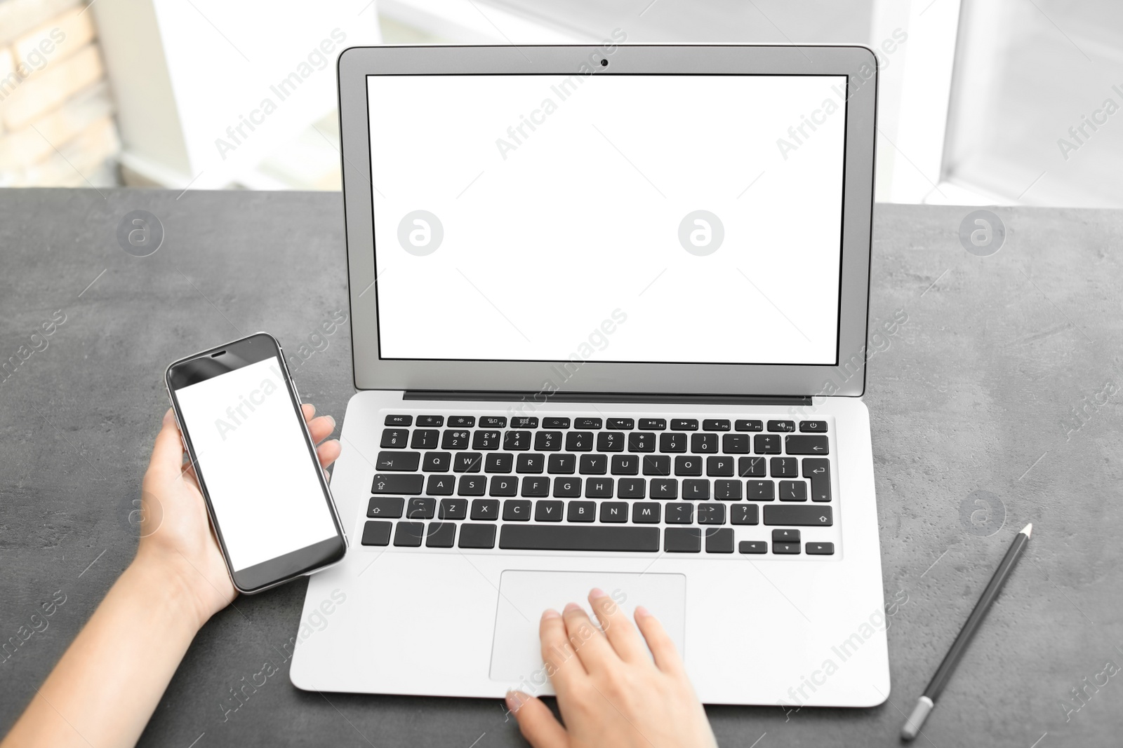 Photo of Woman working with laptop and smartphone at table. Mock up with space for text