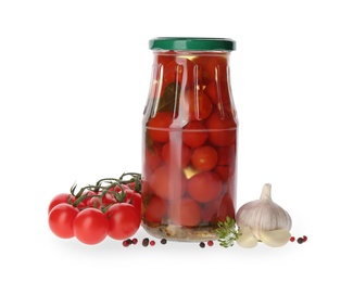 Jar of pickled tomatoes and fresh ingredients on white background