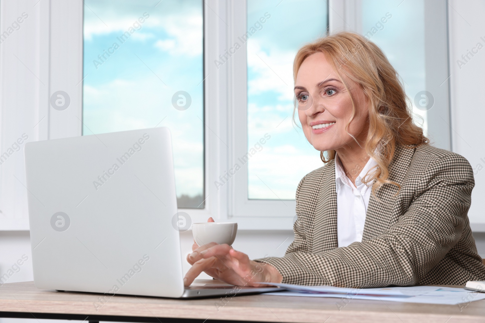 Photo of Lady boss working on laptop at desk in office. Successful businesswoman