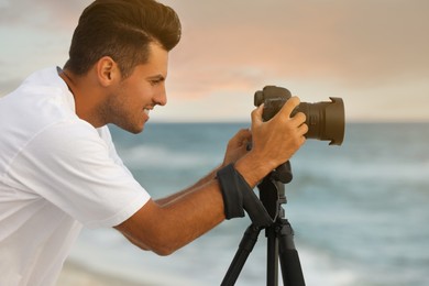 Photographer working with professional camera near sea