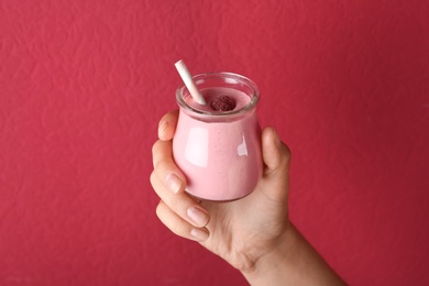 Image of Woman with tasty raspberry smoothie on red background, closeup