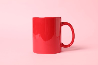 Photo of One red ceramic mug on pink background