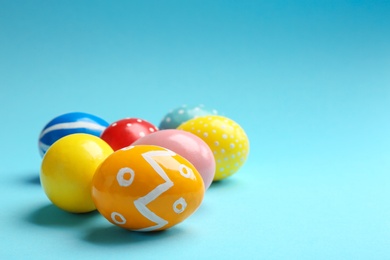 Photo of Painted Easter eggs on color background, space for text