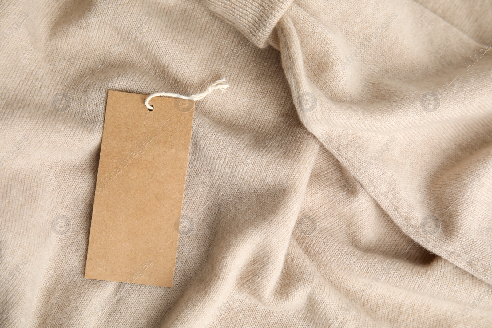 Photo of Warm beige cashmere sweater with tag, closeup